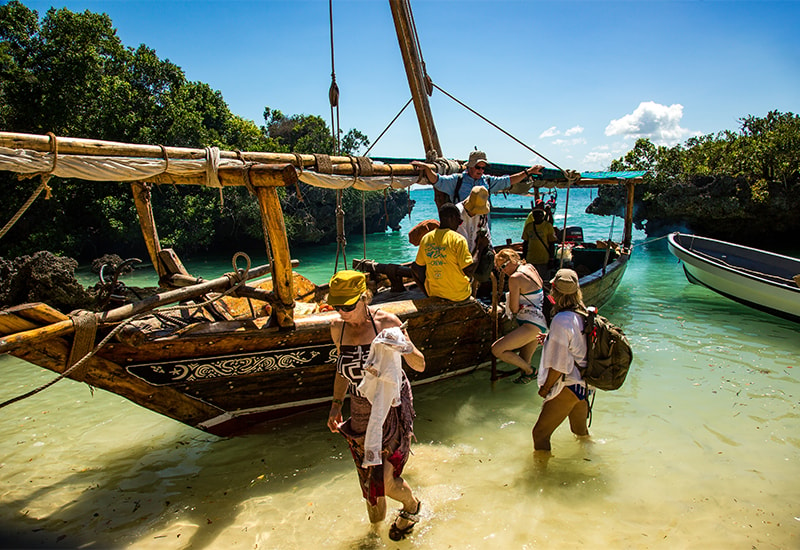 guests exiting a dhow sailing boat on the Zanzibar coastline