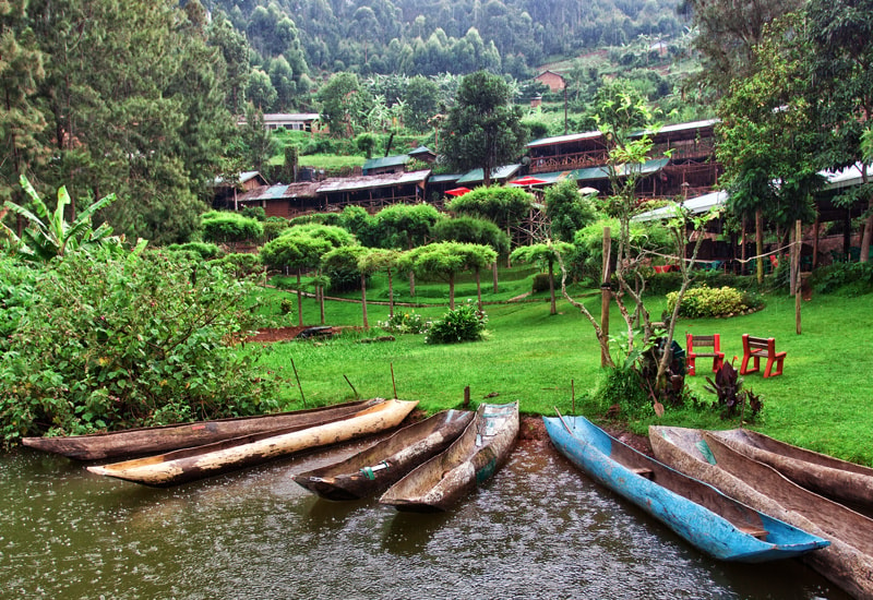 Lush forest and traditional boats at Lake Bunyonyi in Uganda