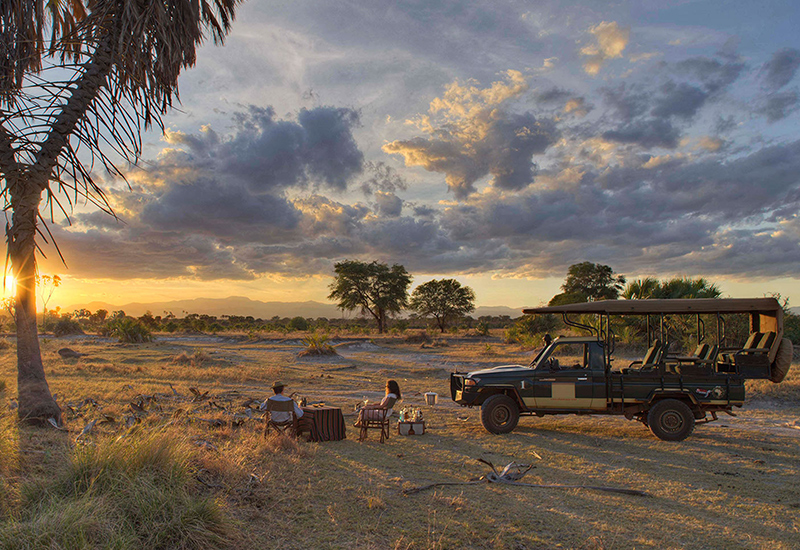 two people having sundowners on a game drive in kenya