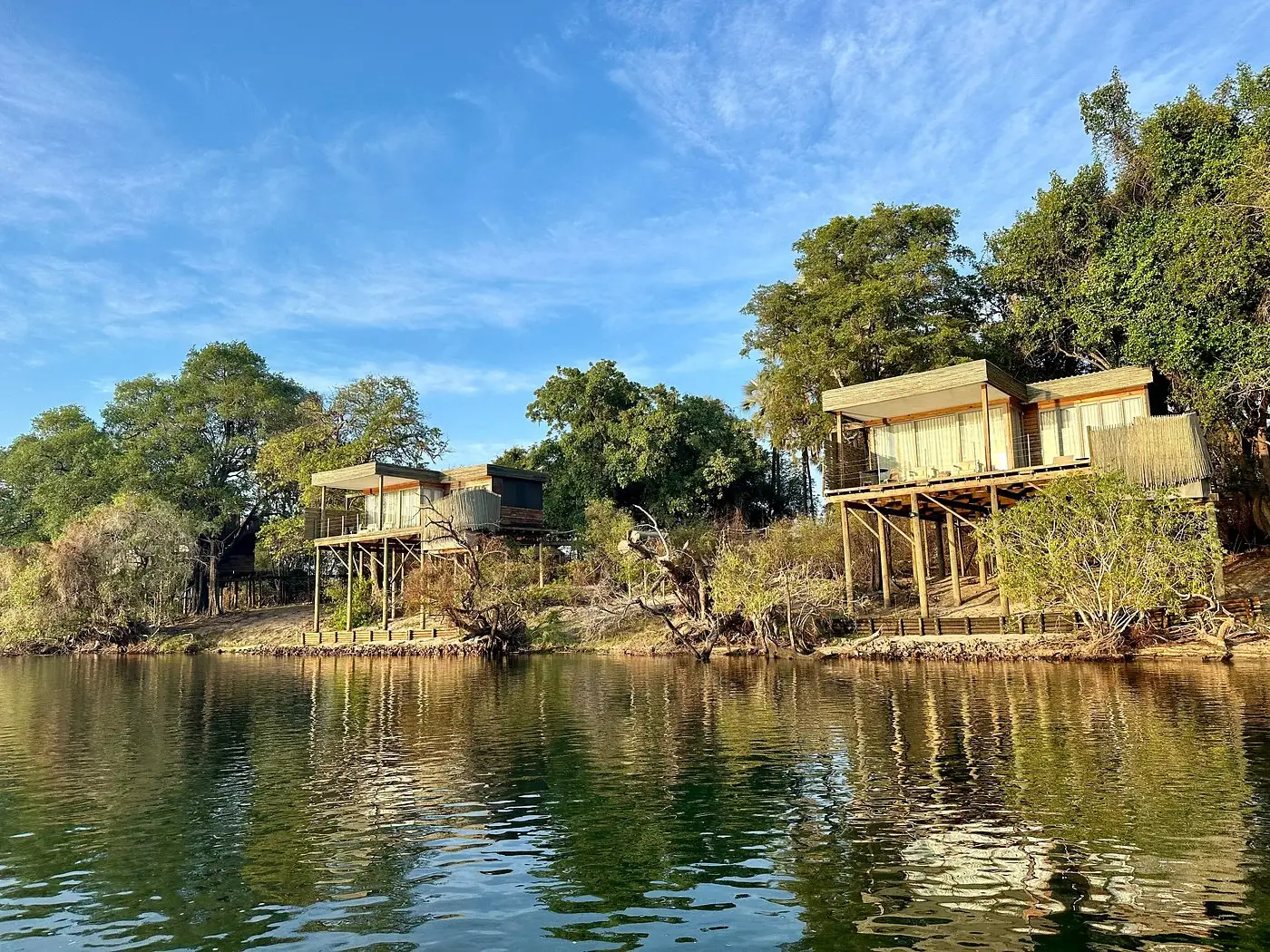 Our American guests from Florida capturing a rainbow arching over Victoria Falls, observing hippos in the Zambezi River, and viewing their outside suite at Victoria Falls River Lodge - Island Treehouse Suites